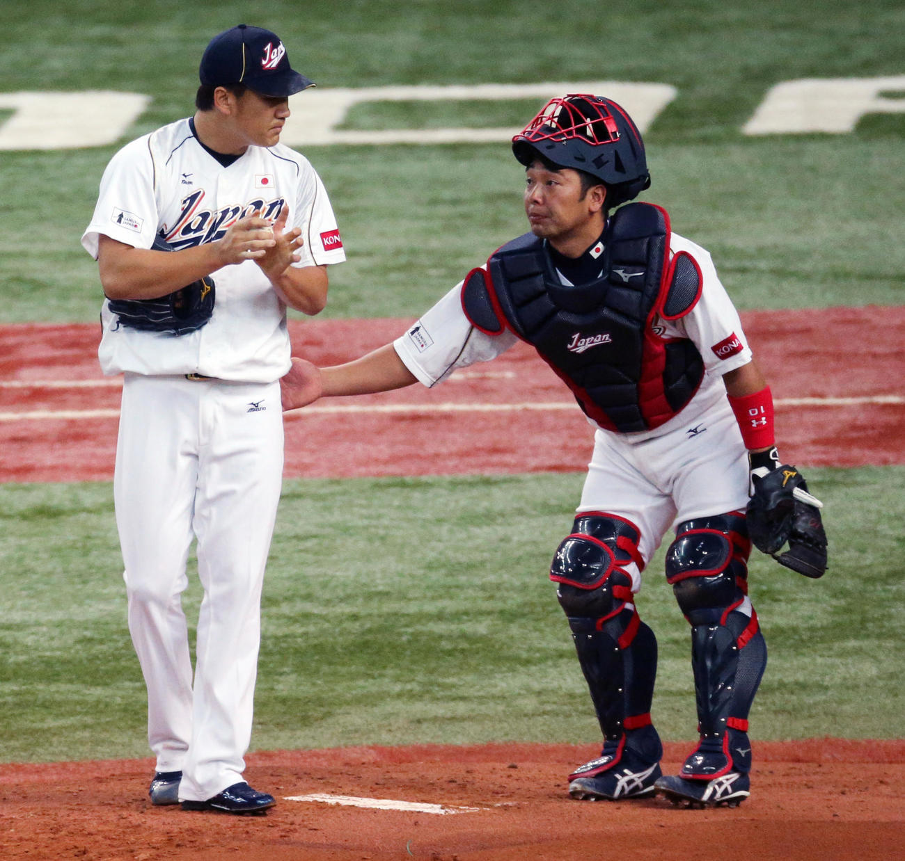 13年WBC壮行試合オーストラリア戦、1回に押し出し死球を与えた田中将大（左）に駆け寄る阿部慎之助