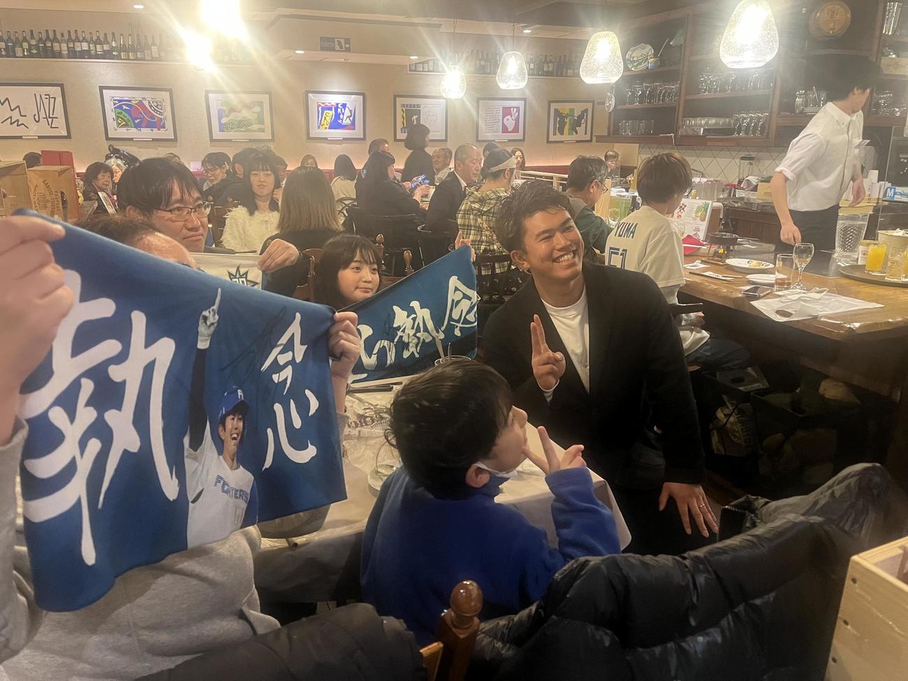 札幌市内のレストランで行われたトークイベントでファンと写真撮影する日本ハム今川（中央）（撮影・永野高輔）