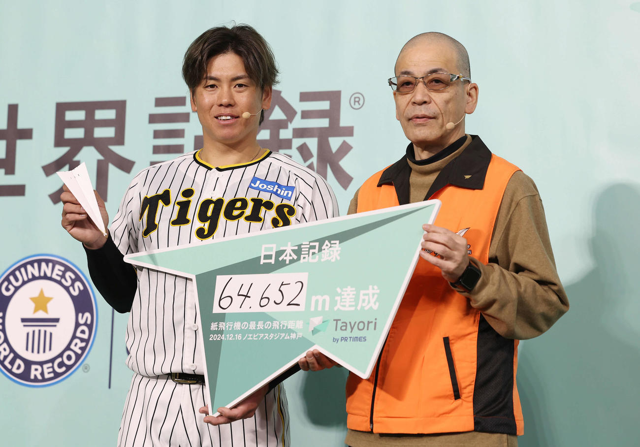 紙飛行機最長飛距離の日本記録を達成した阪神梅野。右は前日本記録保持者の藤原宣明さん（撮影・前田充）