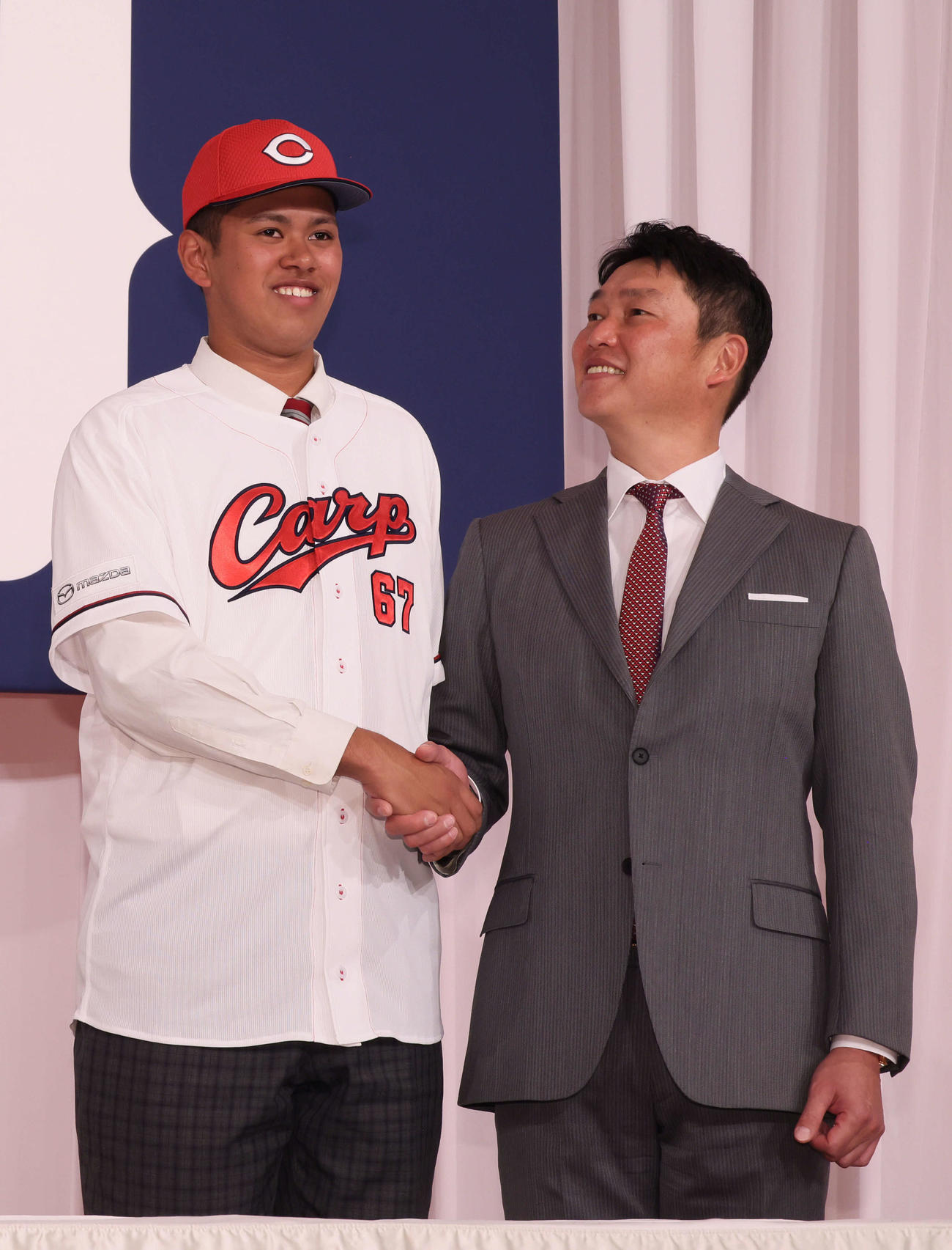 新入団選手会見で、身長2メートルのドラフト5位の菊地を見上げる新井監督（撮影・加藤孝規）
