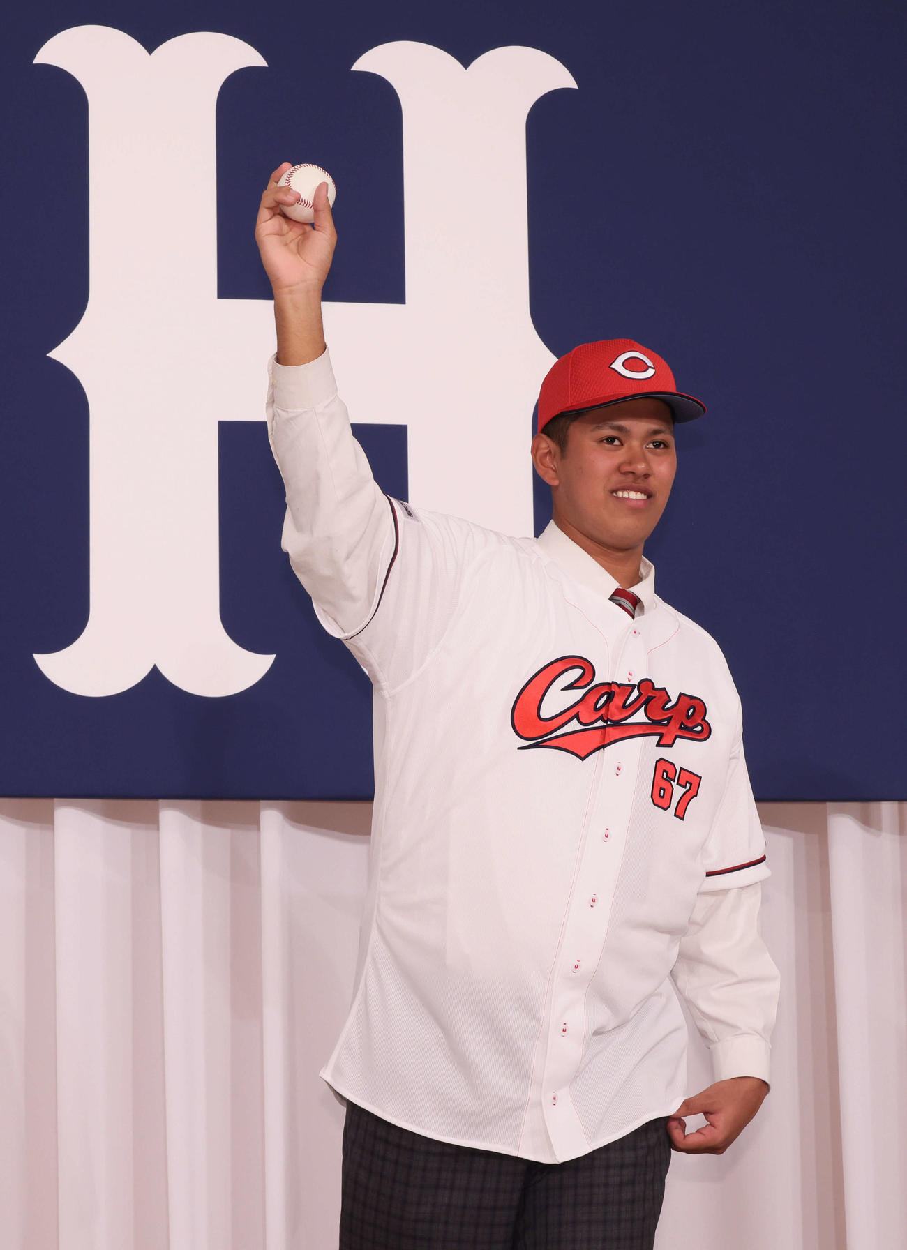 新入団選手会見で、ポーズを決めるドラフト5位の菊地（撮影・加藤孝規）