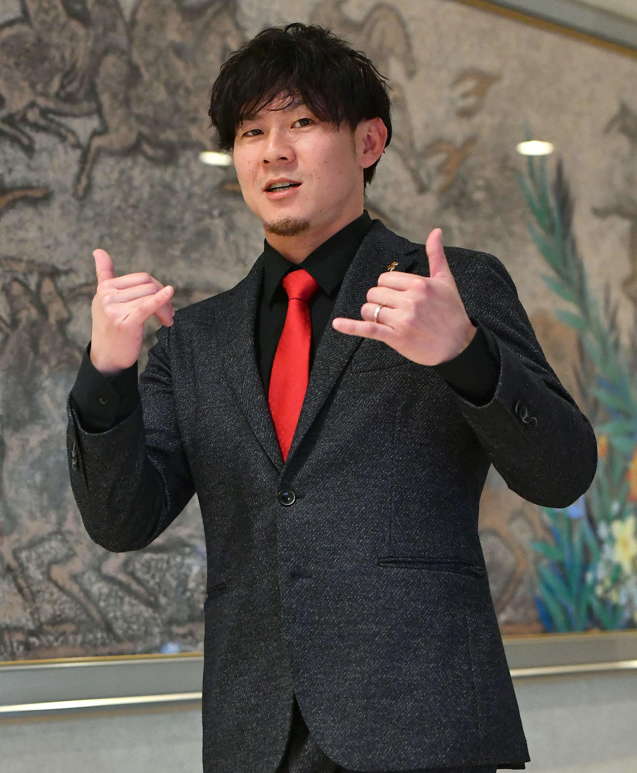 契約更改を終え、アロハポーズを見せながら会見場に入る牧原大（撮影・岩下翔太）