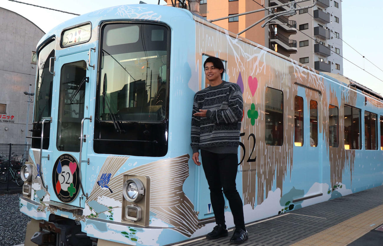 西武鉄道とのコラボイベント「52席の至福」に登場し、車両の前でポーズを決める西武・西川（撮影・佐瀬百合子）