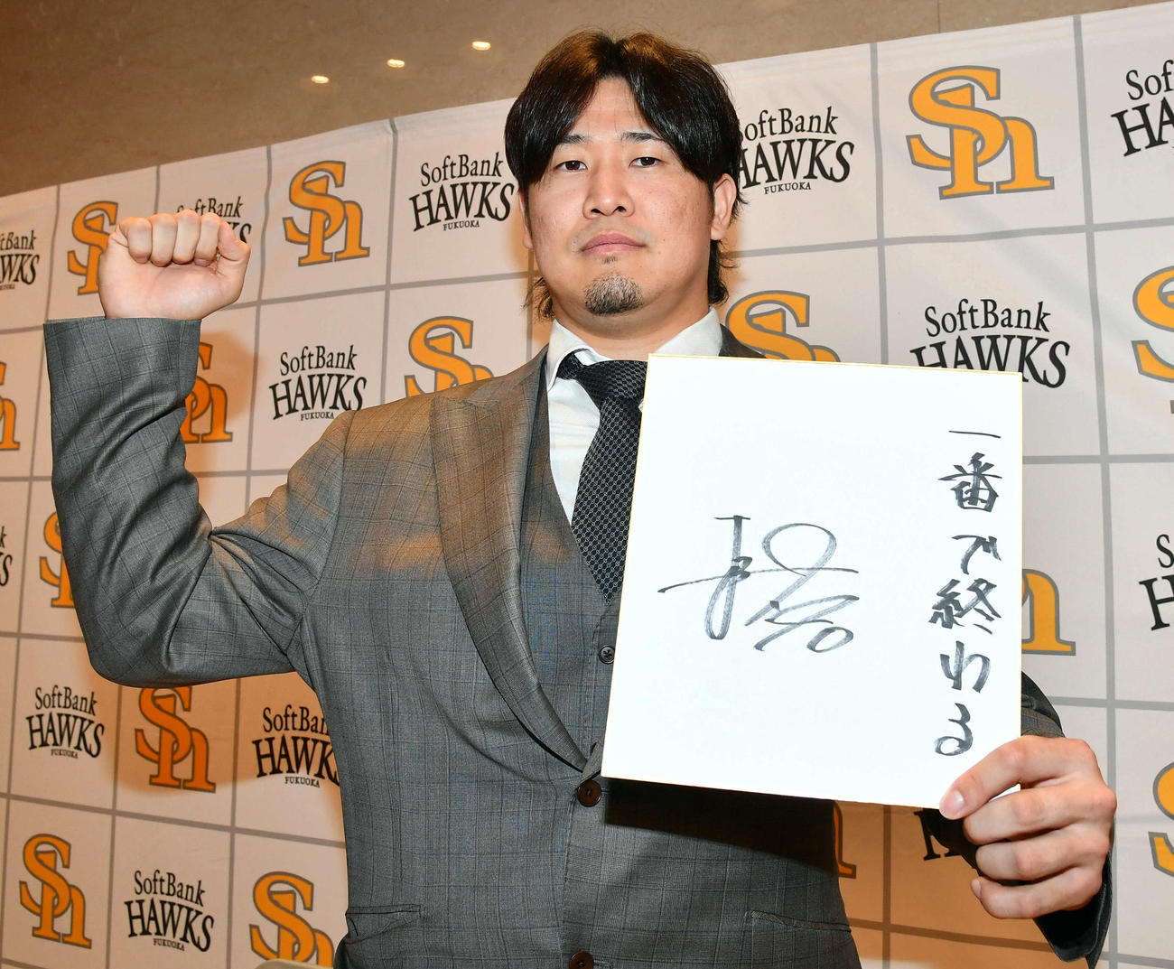 大幅増で契約更改した杉山は、色紙に来季の目標を「一番で終わる」と記してガッツポーズ（撮影・岩下翔太）