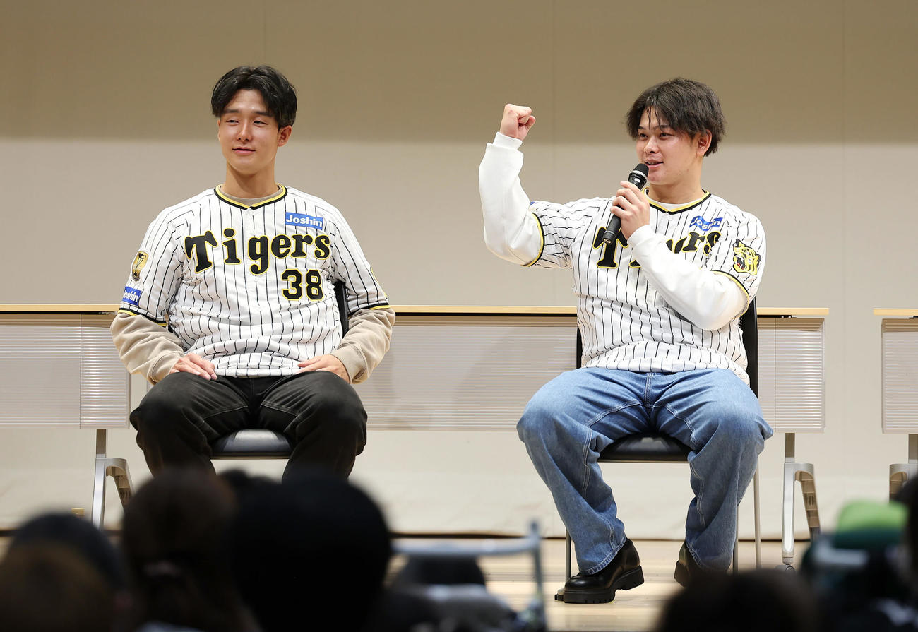 「手をつなぐ市民のつどい　阪神タイガース選手とともに」に参加し、参加者の質問に答えガッツポーズする阪神野口。左は小幡（撮影・前田充）