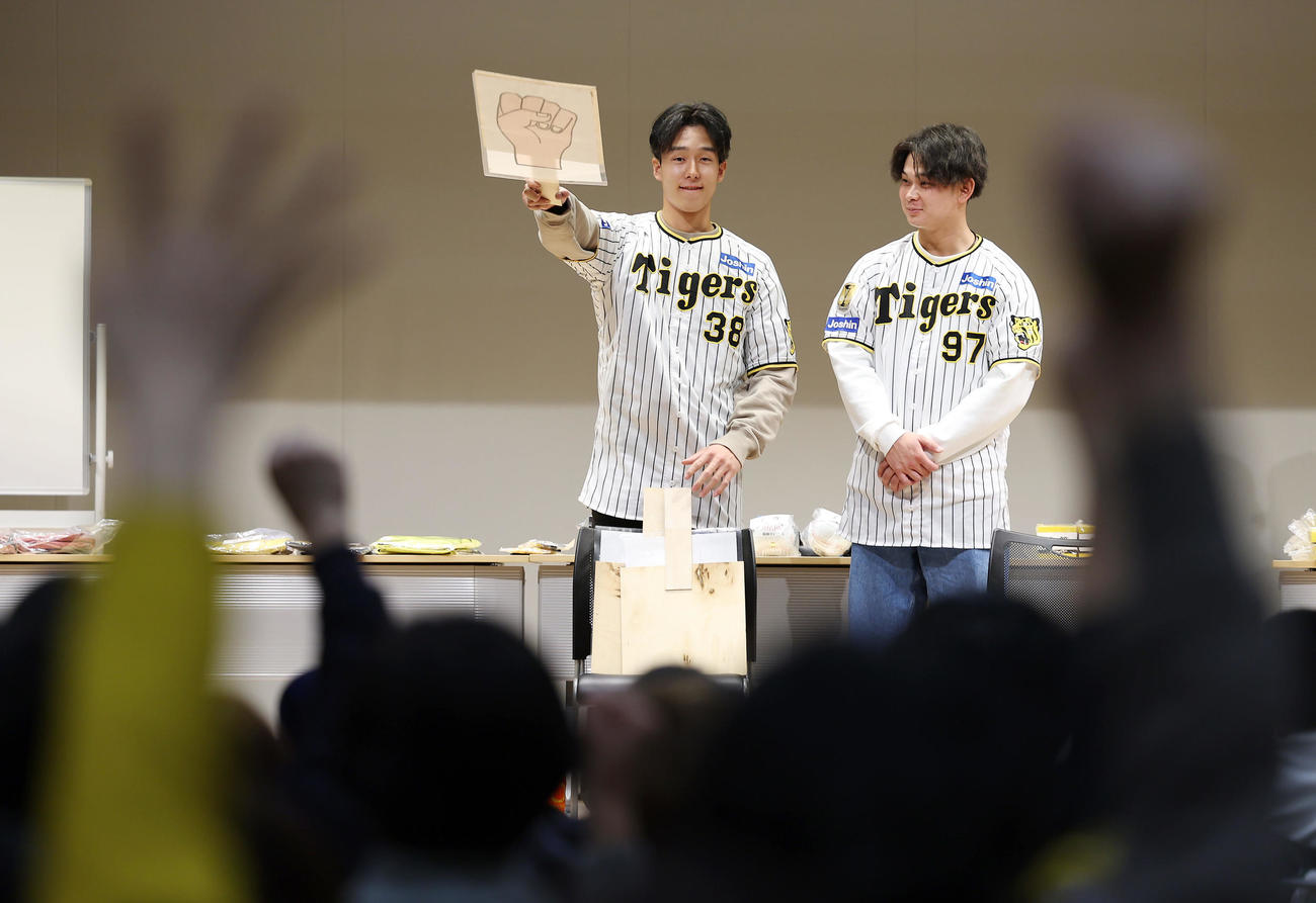 「手をつなぐ市民のつどい　阪神タイガース選手とともに」に参加し、参加者とじゃんけんゲームを楽しむ阪神小幡（左）と野口（撮影・前田充）
