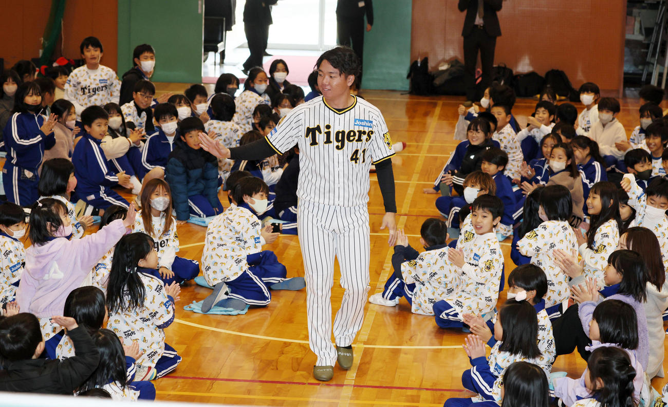 母校の小学校を訪れ子供たちの間を通って入場する村上（撮影・加藤哉）