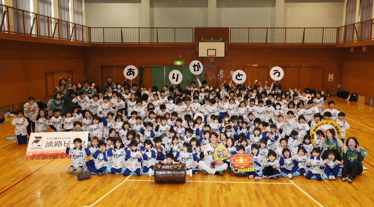 母校の小学校を訪れて子供たちと記念写真に納まる村上（撮影・加藤哉）