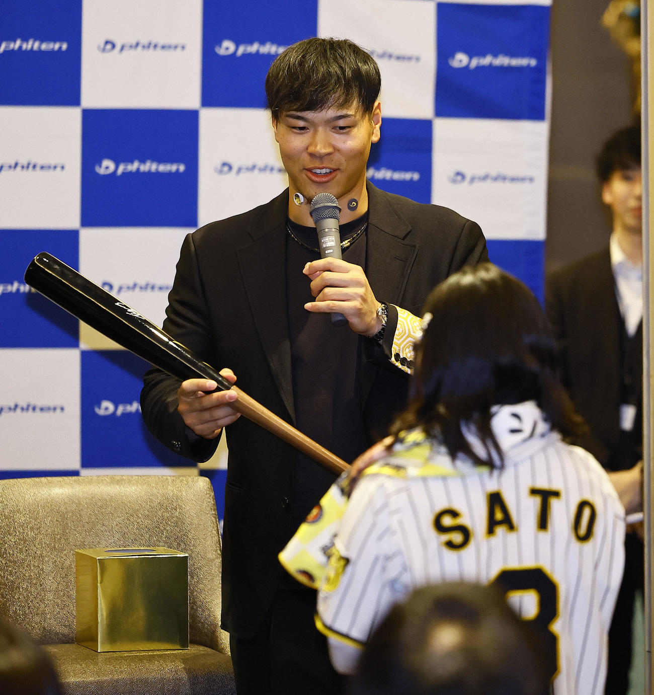 ファイテンファンミーティングの抽選会で、参加者にプレゼントを渡す阪神佐藤輝（撮影・藤尾明華）