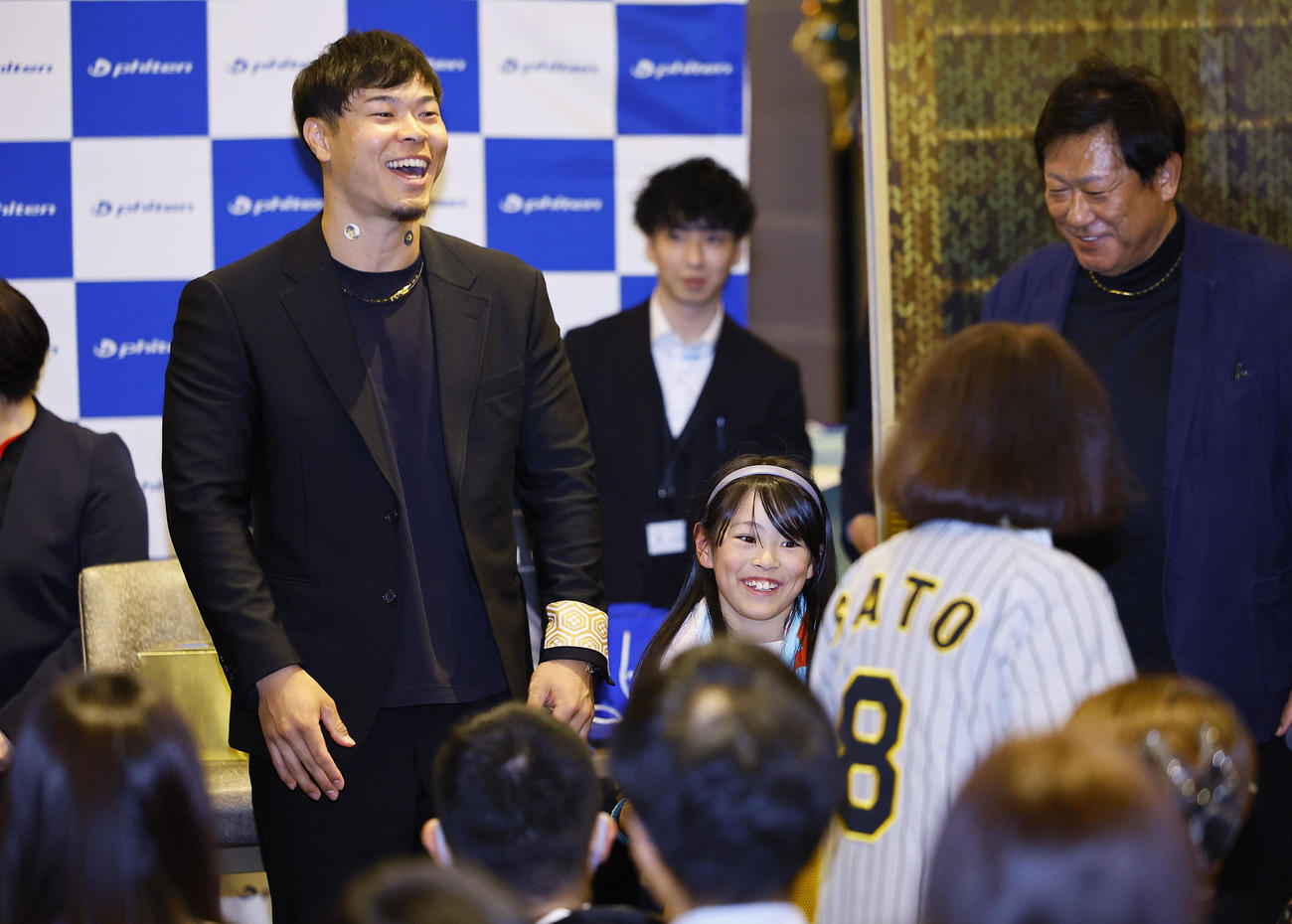 ファイテンファンミーティングの抽選会で、参加者にプレゼントを渡す阪神佐藤輝（撮影・藤尾明華）