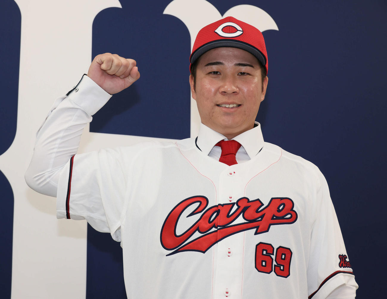 現役ドラフトでオリックスから広島に移籍した山足は入団会見でポーズを決める（撮影・加藤孝規）