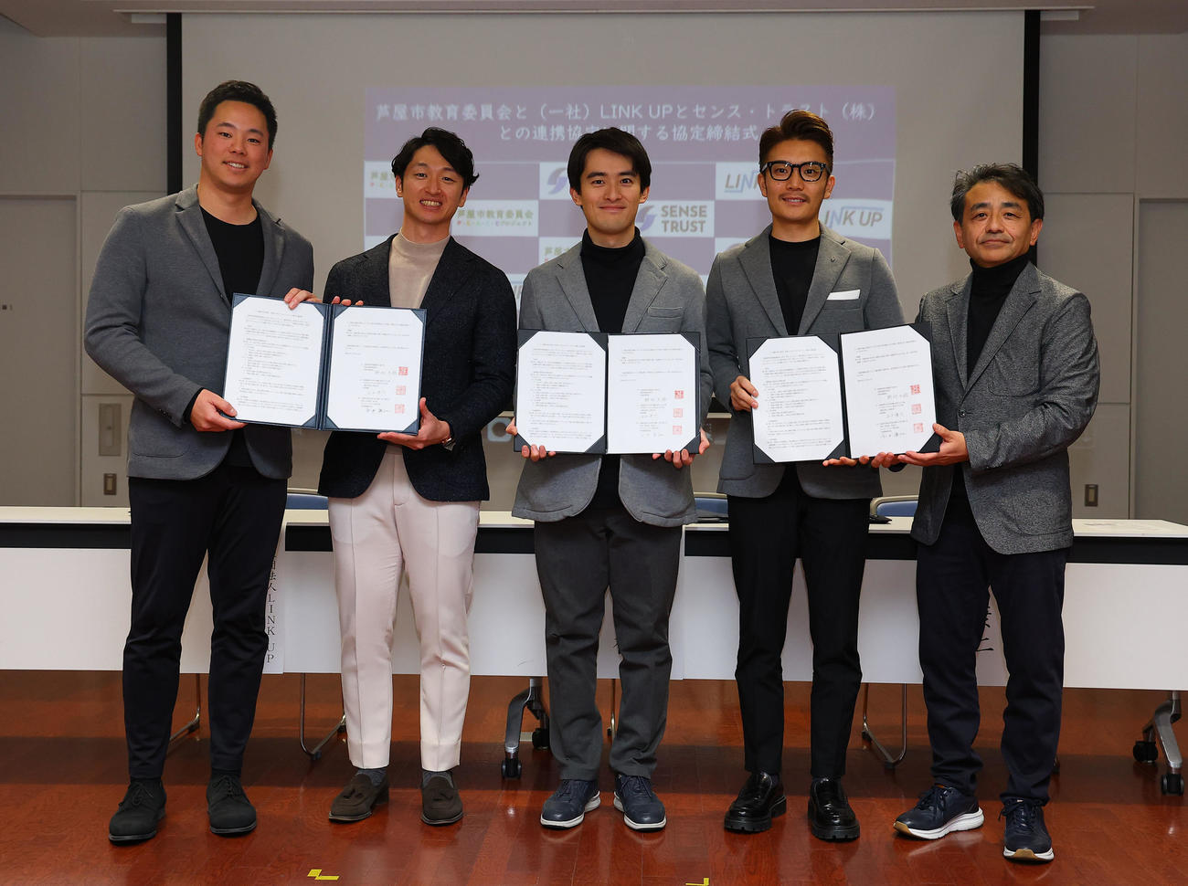 芦屋市との協定を締結し、写真に納まる左から一般社団法人LINK UP石井僚介代表理事、阪神近本光司、高島崚輔芦屋市長、センス・トラスト株式会社の今中康仁社長、野村大祐芦屋市教育委員長（撮影・藤尾明華）