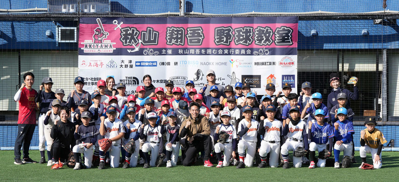 野球教室に参加した子どもたちと笑顔で記念撮影に納まる広島秋山（前列中央）左端は小泉氏（撮影・たえ見朱実）