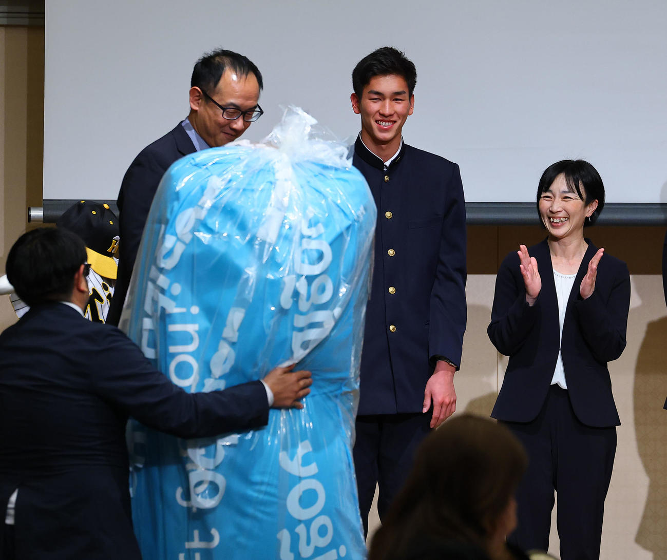 報徳学園入団激励会で、父母会から巨大クッションを贈られる阪神ドラフト2位の今朝丸（右から2人目）（撮影・藤尾明華）