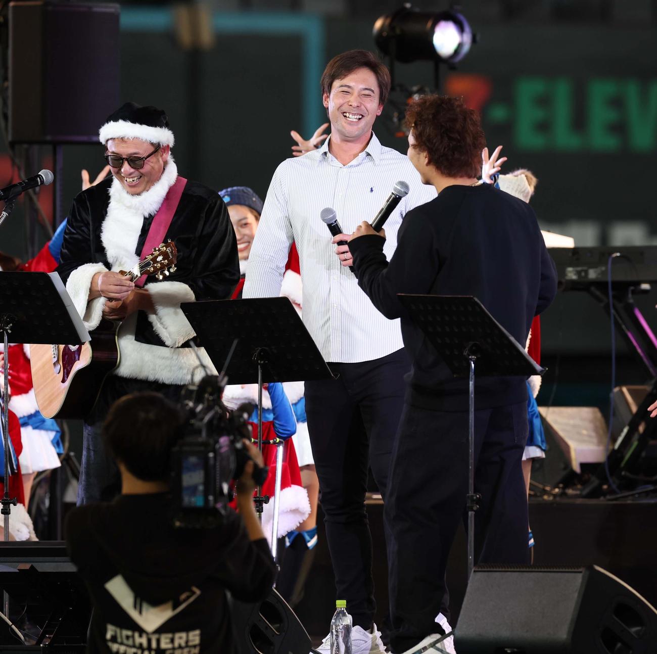 エスコンフィールド北海道で開催された音楽イベントで歌い終わり笑顔の左から岩本氏、日本ハム上原、奈良間（撮影・黒川智章）