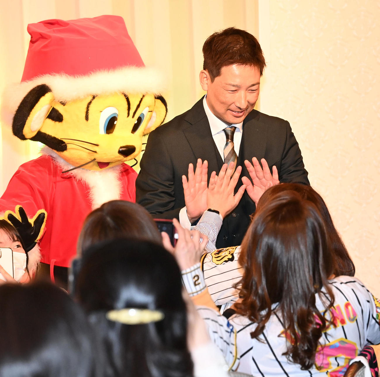 ファンクラブイベントのクリスマスパーティーでファンと笑顔でタッチする岩崎（撮影・前岡正明）