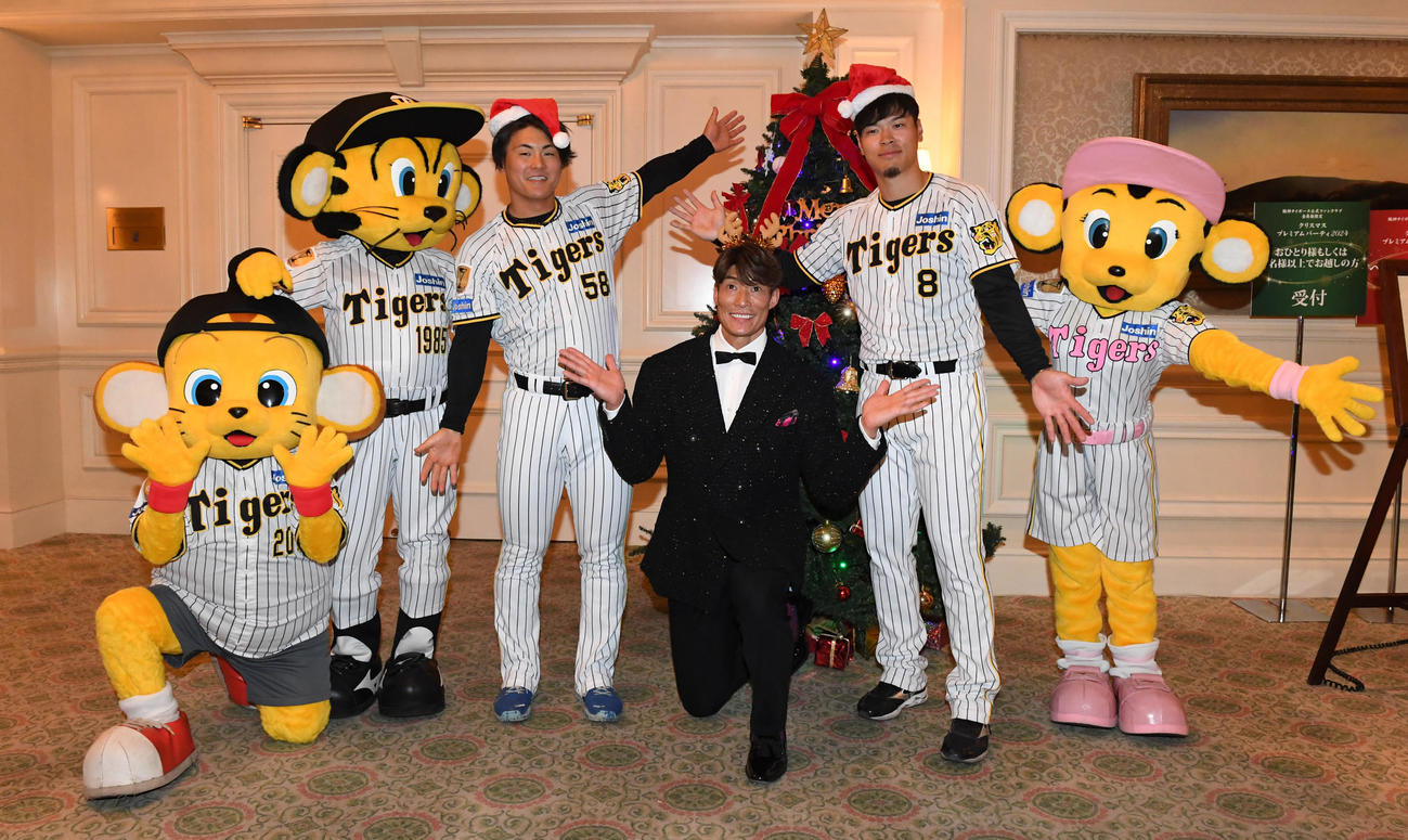 ファンクラブイベントのクリスマスパーティーに出演した左から前川、糸井嘉男氏、佐藤輝はツリーの前で記念撮影（撮影・前岡正明）
