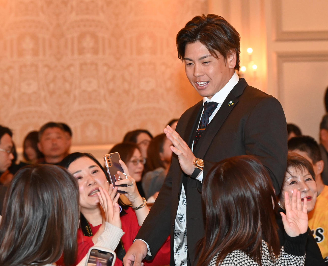 ファンクラブイベントのクリスマスパーティーでファンと笑顔でタッチする梅野（撮影・前岡正明）