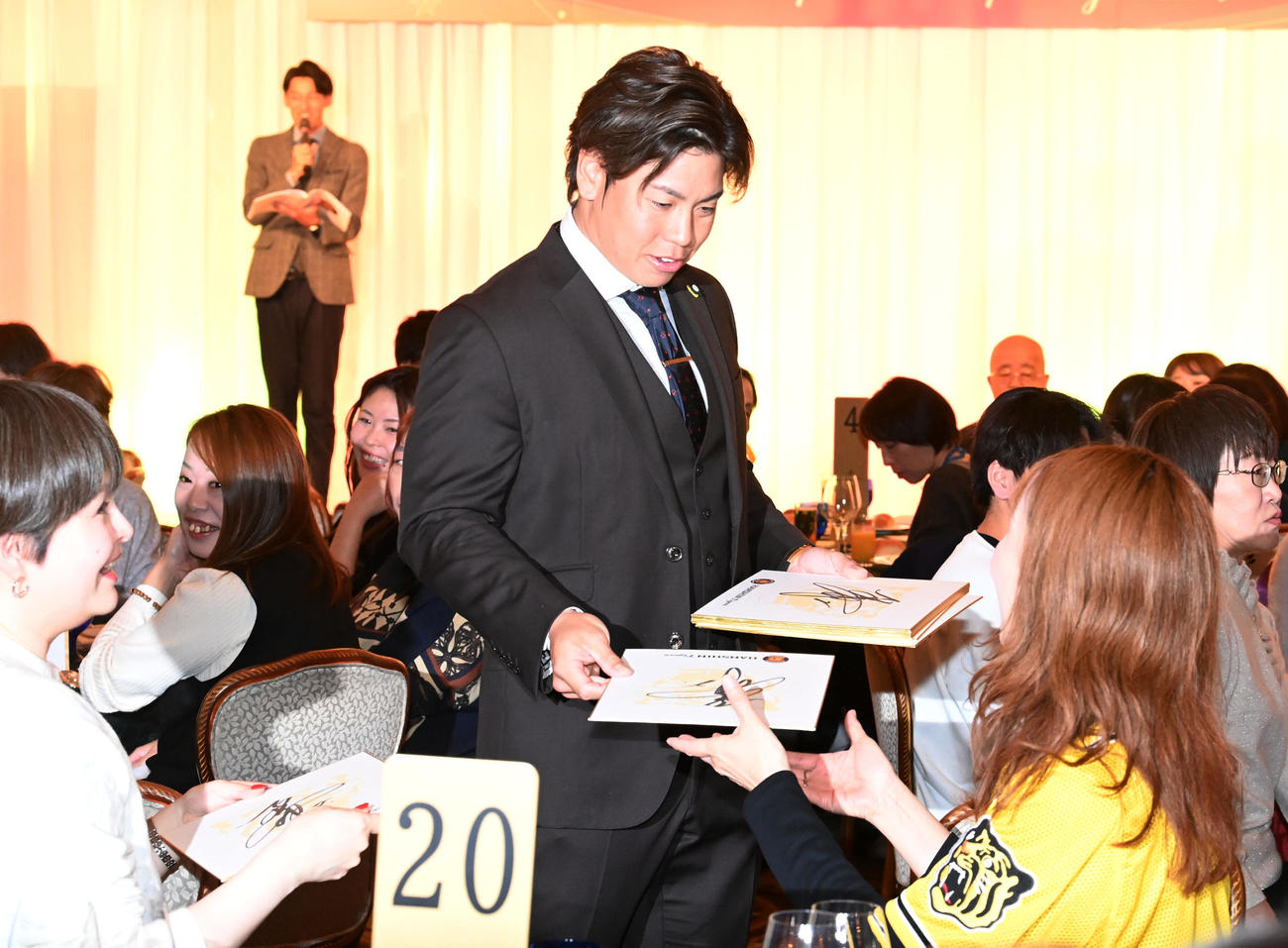 ファンクラブイベントのクリスマスパーティーでファンにサイン色紙をプレゼントする梅野（撮影・前岡正明）