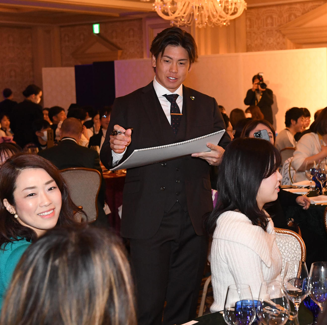 ファンクラブイベントのクリスマスパーティーでファンとクイズの答えを考える梅野（撮影・前岡正明）