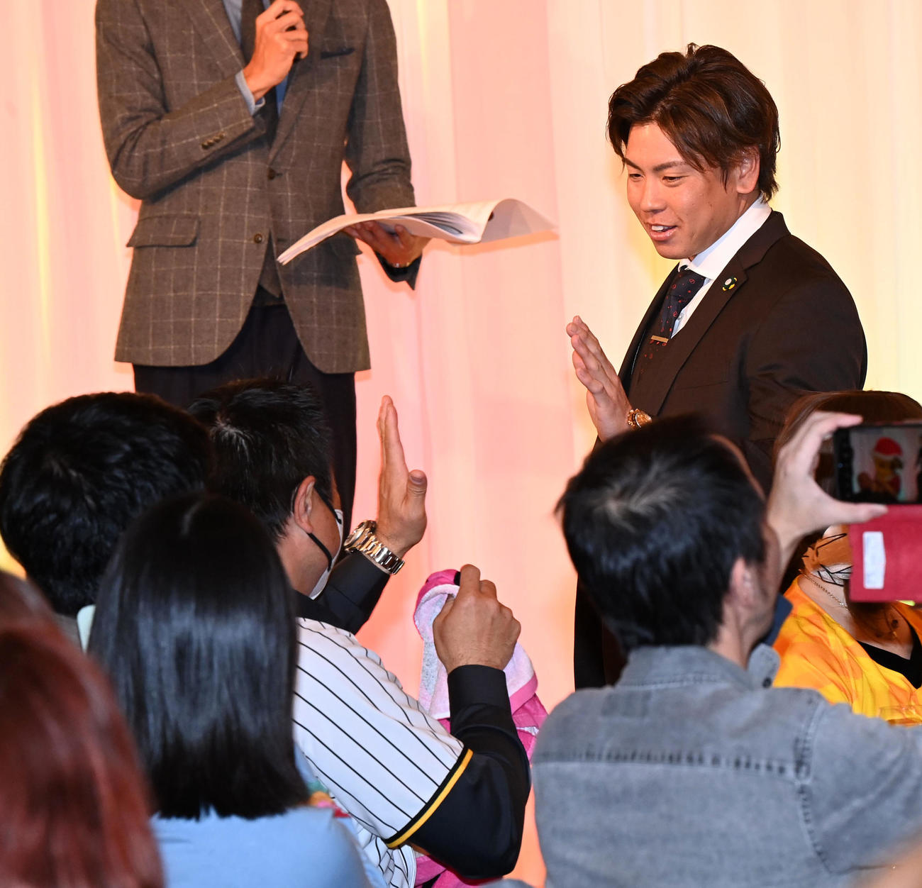 ファンクラブイベントのクリスマスパーティーでファンと笑顔でタッチする梅野（撮影・前岡正明）