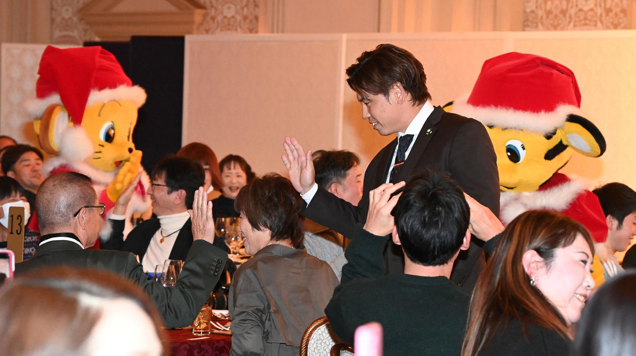 ファンクラブイベントのクリスマスパーティーでファンと笑顔でタッチする梅野（撮影・前岡正明）