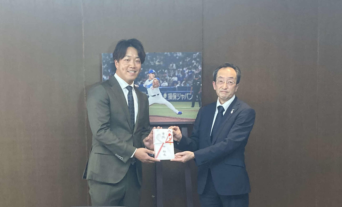 主催したチャリティーコンペで集まった寄付金を寄贈した中日柳（左）