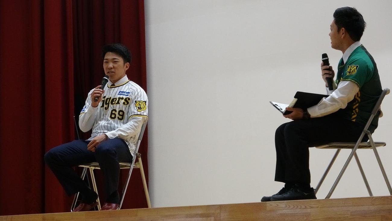 秋田市立旭川小学校を訪問した阪神石井（左）（球団提供）