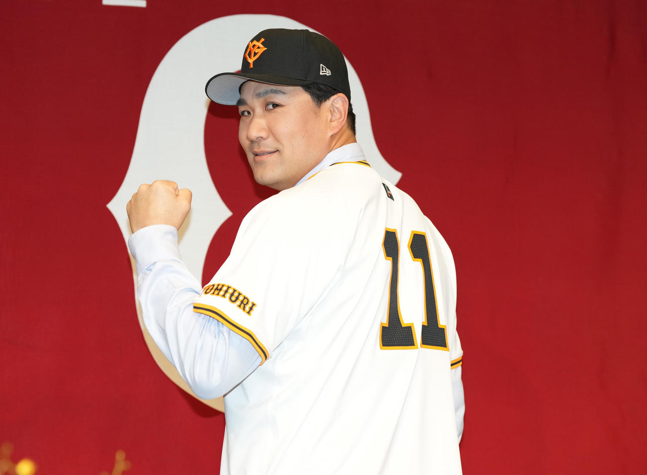 入団会見で、ユニホームを着てガッツポーズする巨人田中将（撮影・鈴木みどり）