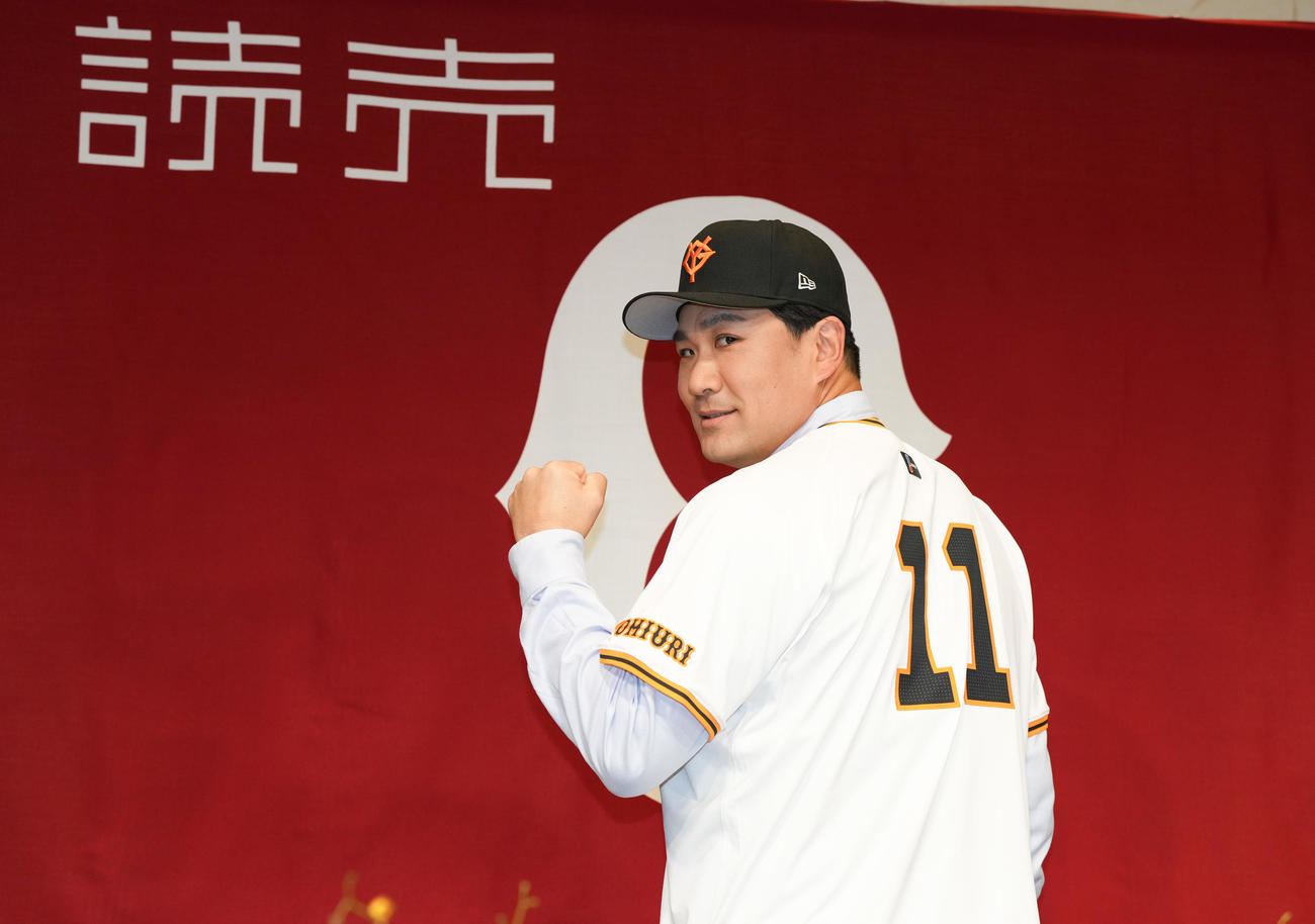 入団会見で、ユニホームを着てガッツポーズする巨人田中将（撮影・鈴木みどり）