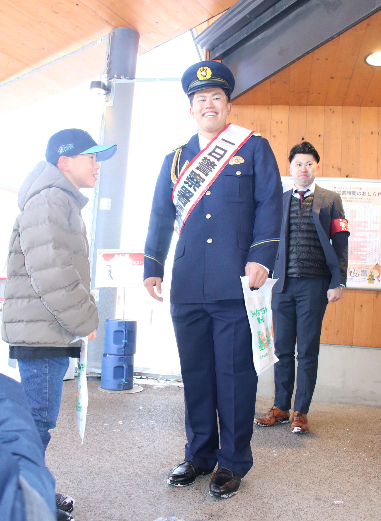 北海道・札幌にある豊平警察署の一日警察署長を務め、商業施設で歳末防犯パトロールを行った日本ハム今川（左）と同行した同署署員の弟駿さん（撮影・木下大輔）
