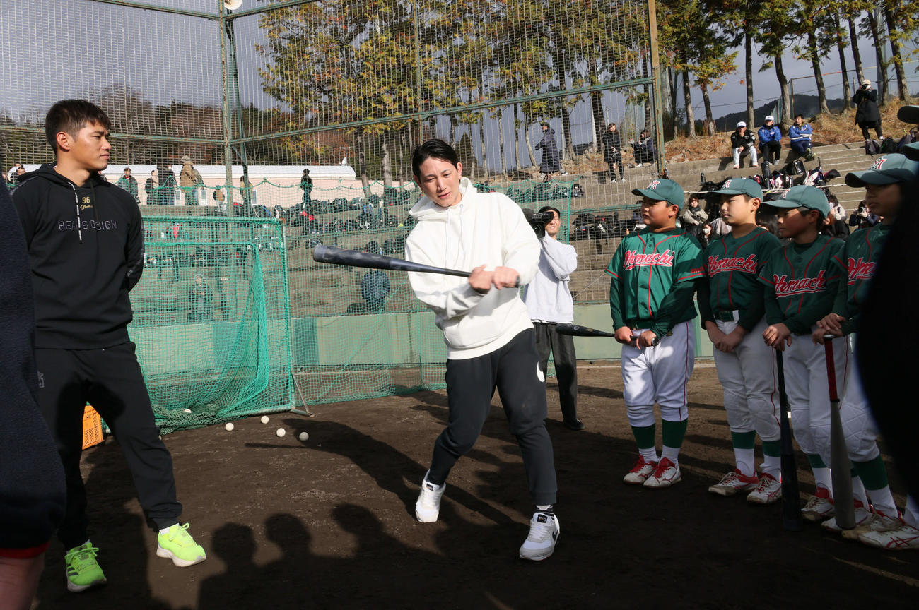 広陵高OB会野球教室で、小学生に打撃指導する巨人小林。左は広島中村奨（撮影・加藤孝規）