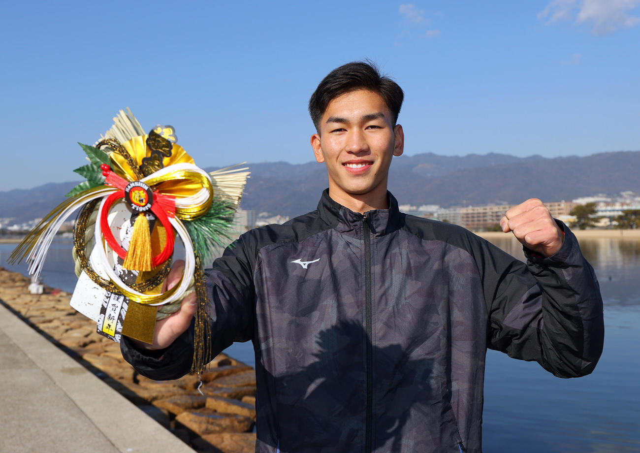 新年を迎えた阪神ドラフト2位の今朝丸は「しめ縄」を手に笑顔でガッツポーズ（撮影・上山淳一）