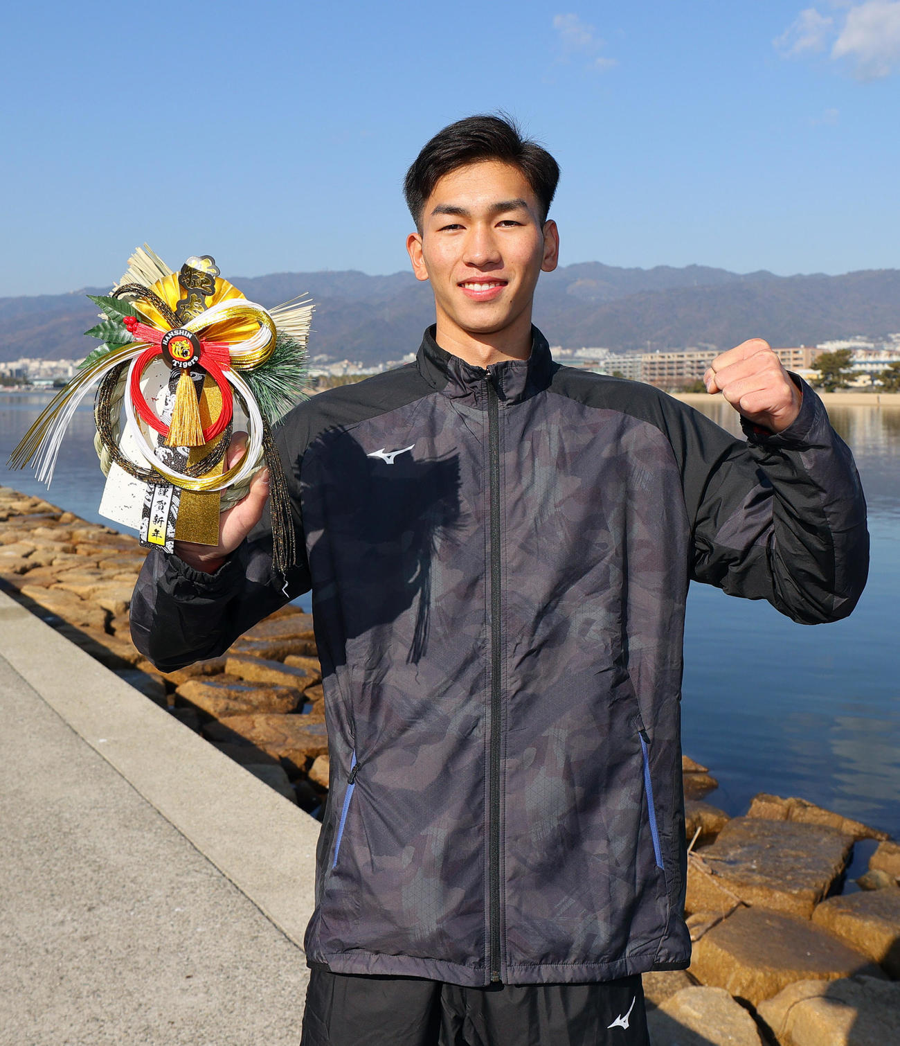 新年を迎えた阪神ドラフト2位の今朝丸は「しめ縄」を手に笑顔でガッツポーズ（撮影・上山淳一）