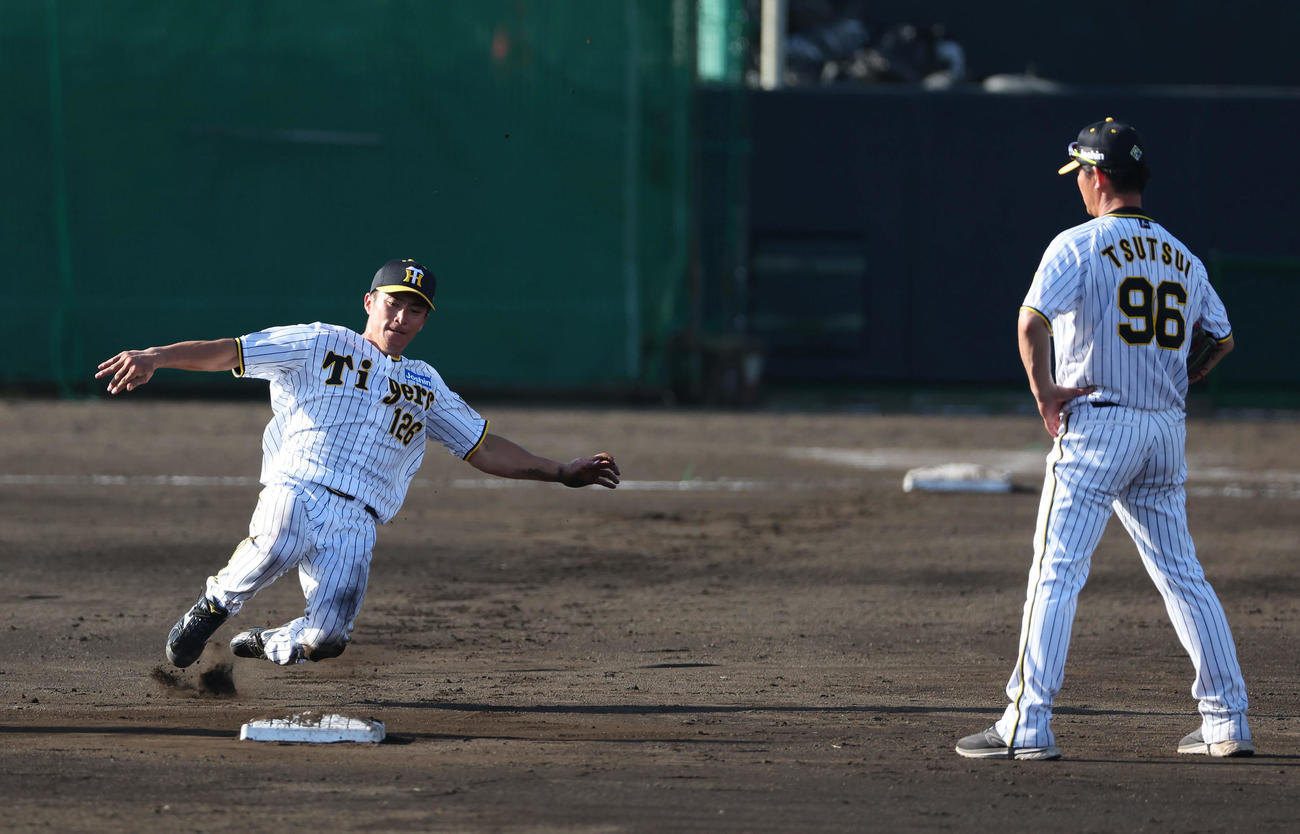 練習試合　阪神対サムスン　居残りで盗塁練習する阪神福島圭音。右は指導する筒井壮外野守備走塁コーチ（2024年2月20日撮影）