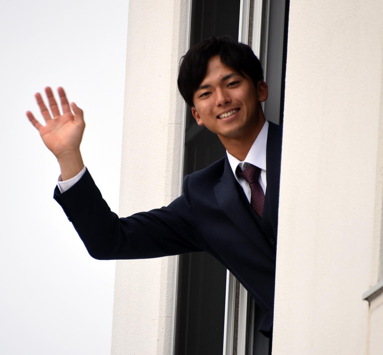 自室から手を振る楽天ドラフト1位の宗山（撮影・山田愛斗）