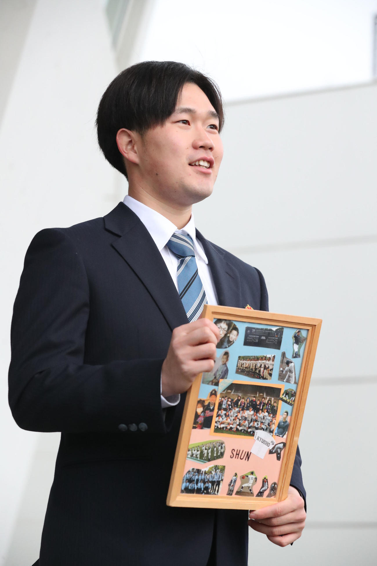 大事な仲間の写真パネルを持ち込んだドラフト3位の安徳投手（撮影・梅根麻紀）