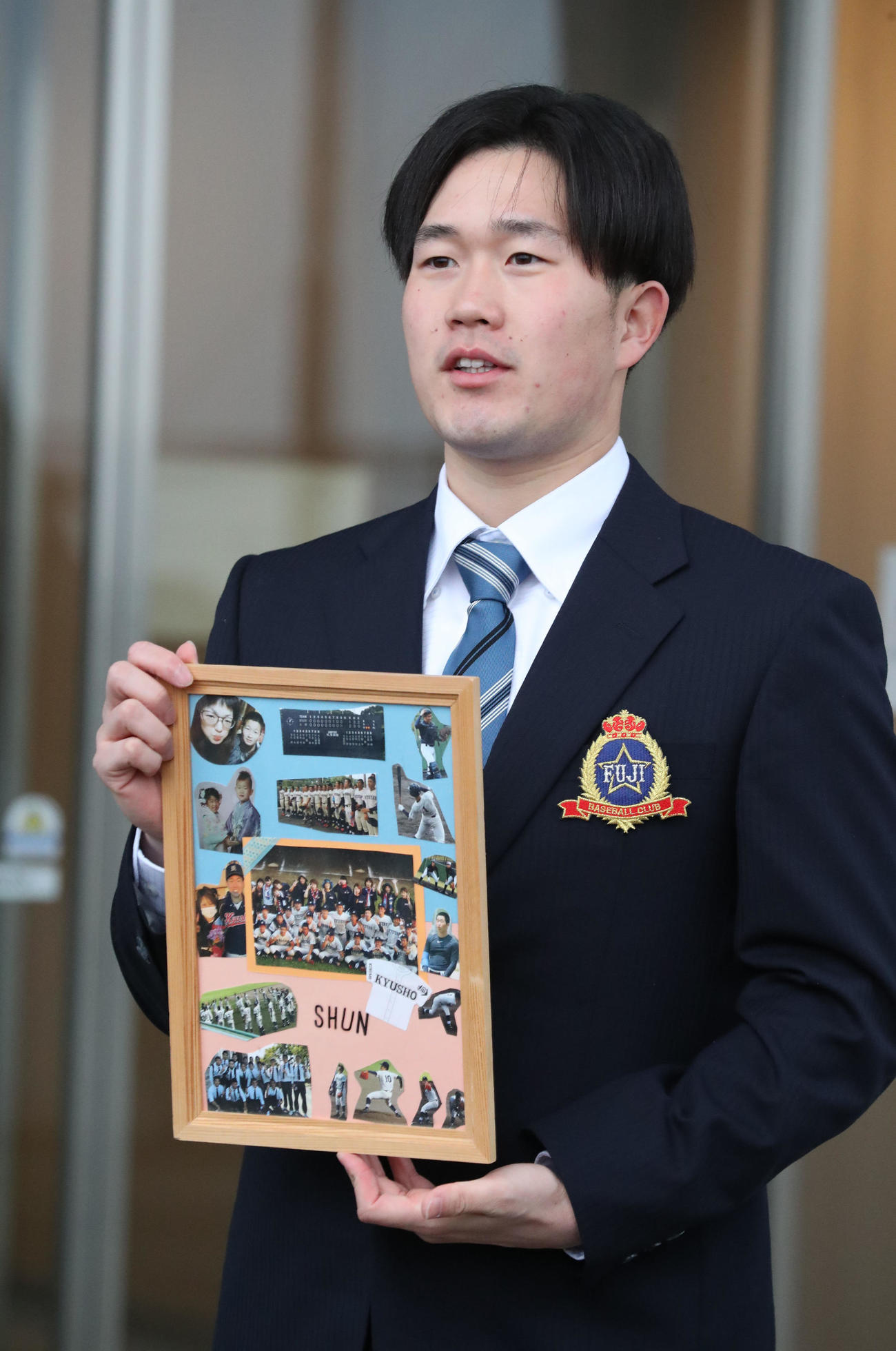 大事な仲間の写真パネルを持ち込んだドラフト3位の安徳投手（撮影・梅根麻紀）