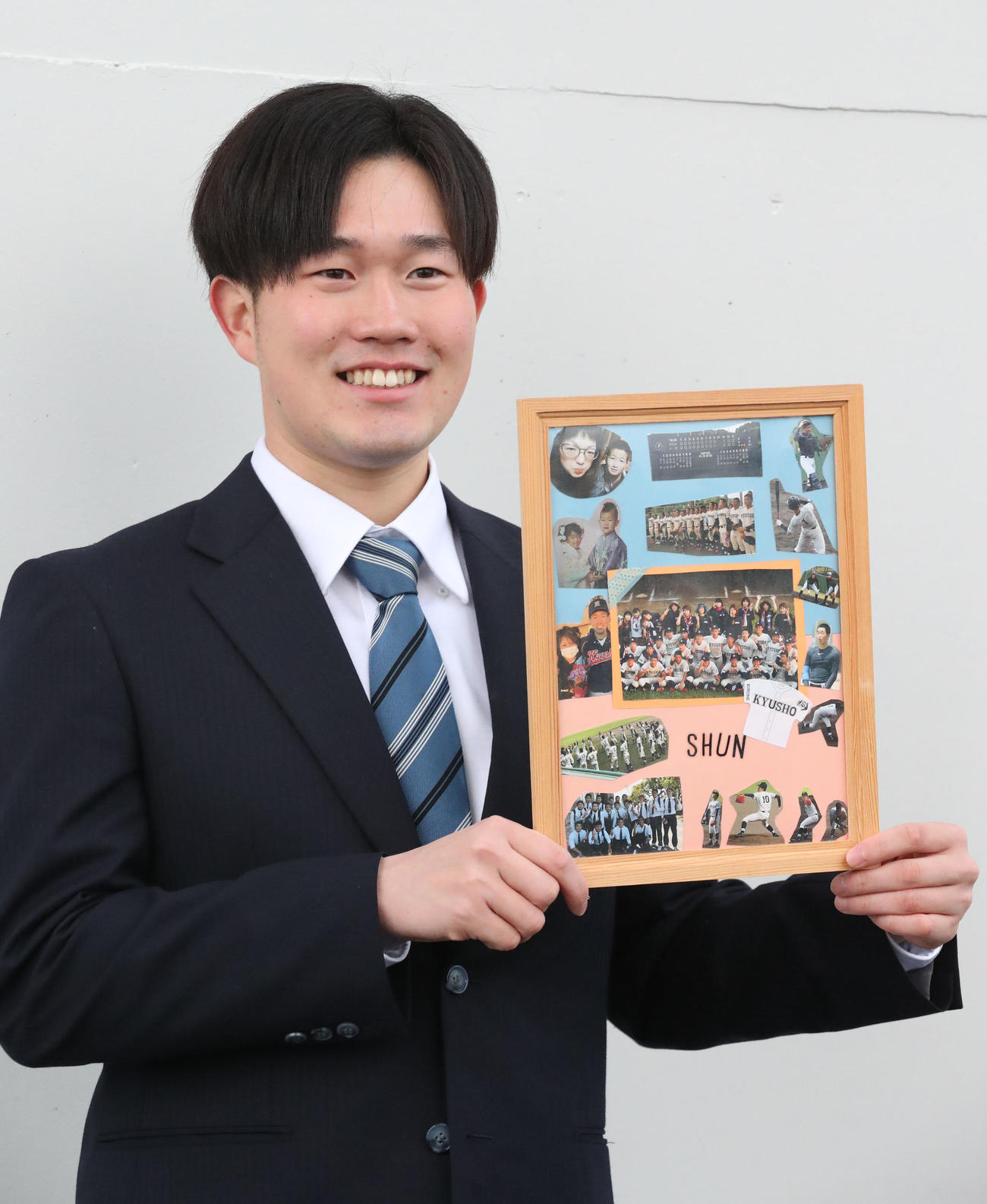 大事な仲間の写真パネルを持ち込んだドラフト3位の安徳投手（撮影・梅根麻紀）