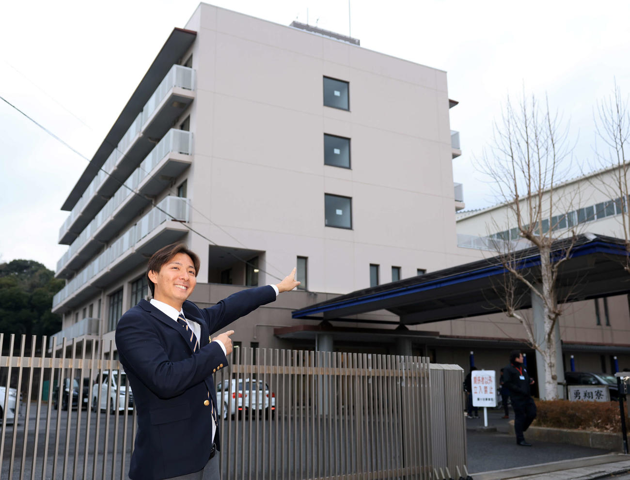 日本ハム勇翔寮に入寮し、寮を笑顔で指さす山城（撮影・浅見桂子）