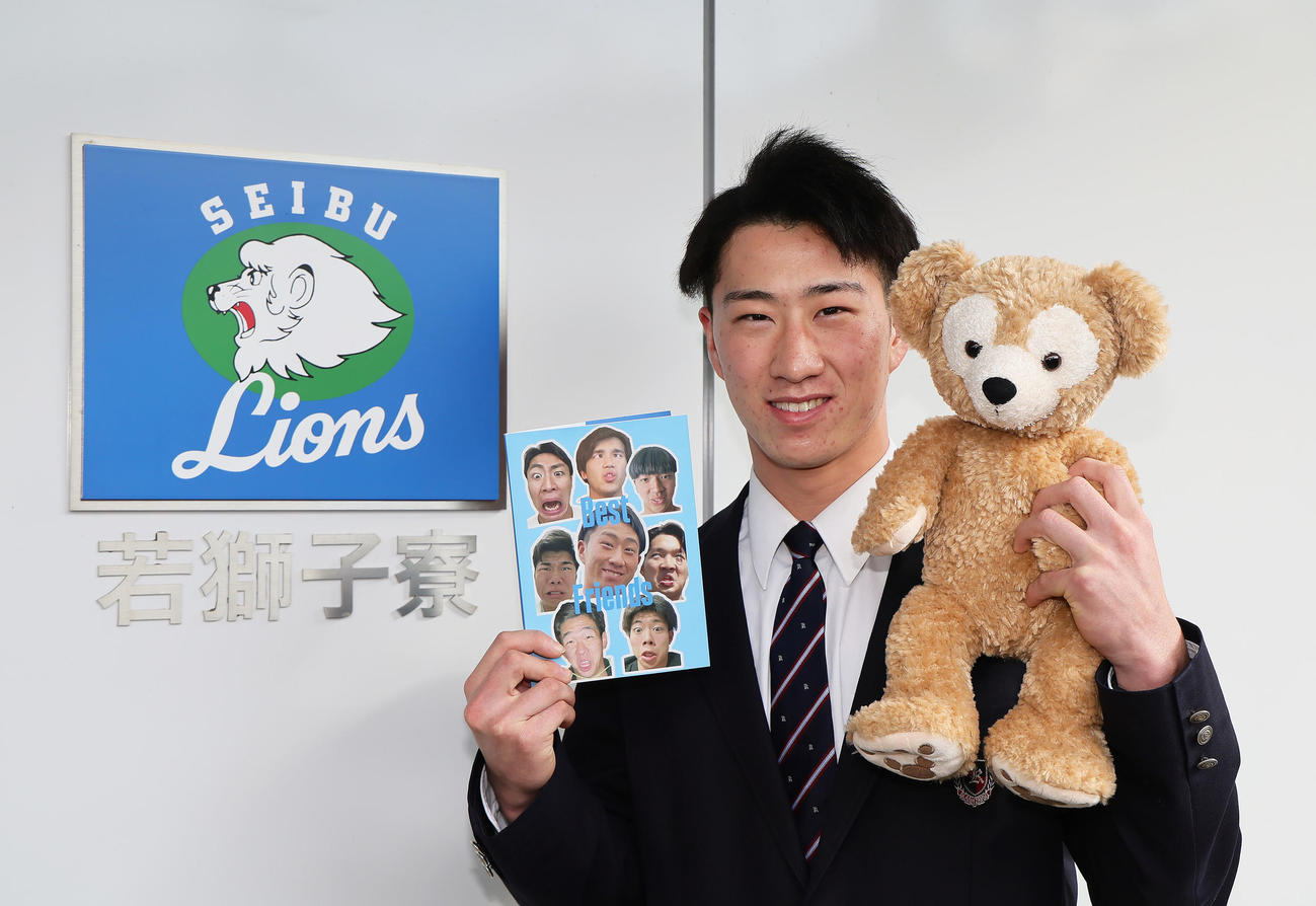 ダッフィーのぬいぐるみとフォトブックを手に入寮した西武ドラフト1位金沢高・斎藤（撮影・足立雅史）