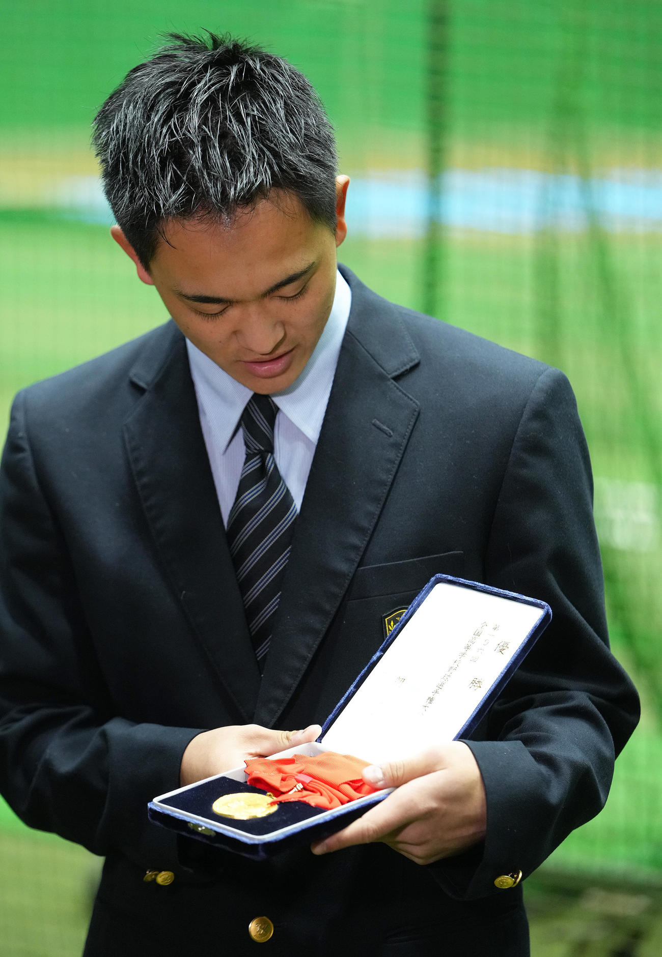 入寮した西武育成5位京都国際高・沢田は持参した甲子園の優勝メダルを見つめる（撮影・足立雅史）