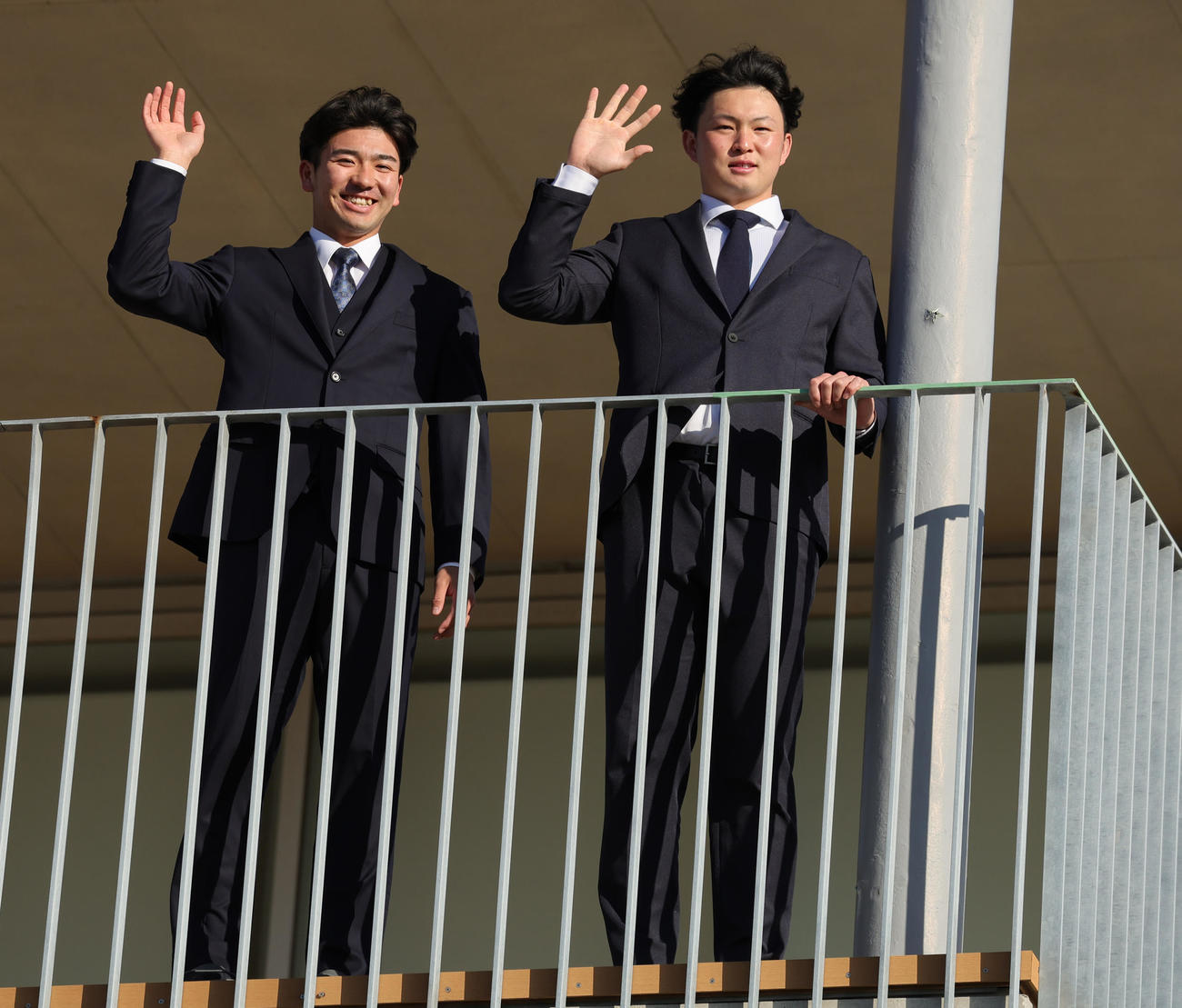 入寮しバルコニーから手を振るDeNA篠木（左）と竹田（撮影・野上伸悟）