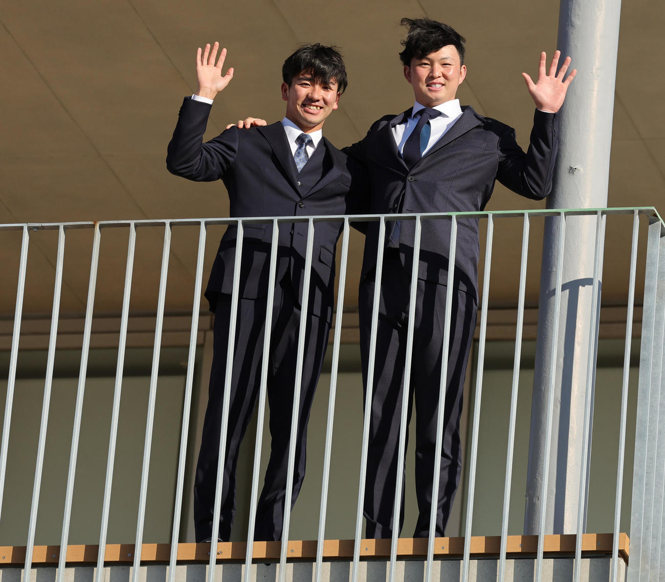 入寮しバルコニーから手を振るDeNA篠木（左）と竹田（撮影・野上伸悟）