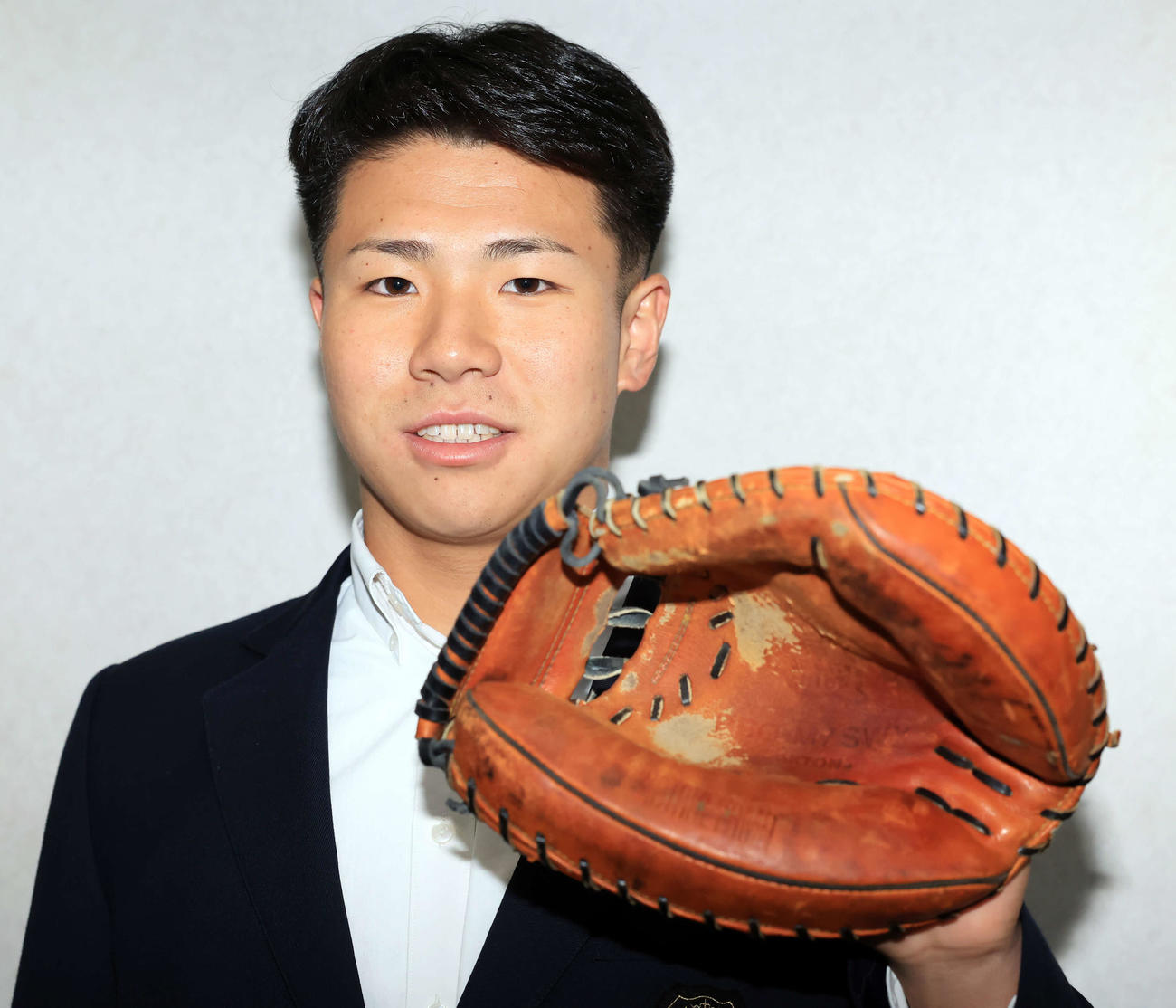 千葉ロッテマリーンズ寮に入寮し、持参したミットを披露する谷村（撮影・浅見桂子）