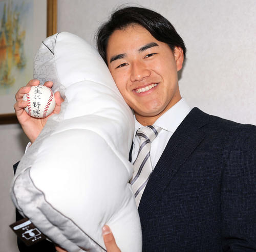 千葉ロッテマリーンズ寮に入寮し、持参したまくらと恩師から贈られたボールを手に笑顔の西川(撮影・浅見桂子)