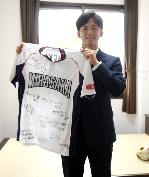 小学生時代のチームメートから贈られた寄せ書きユニホームを持つ楽天ドラフト1位の宗山(撮影・山田愛斗)