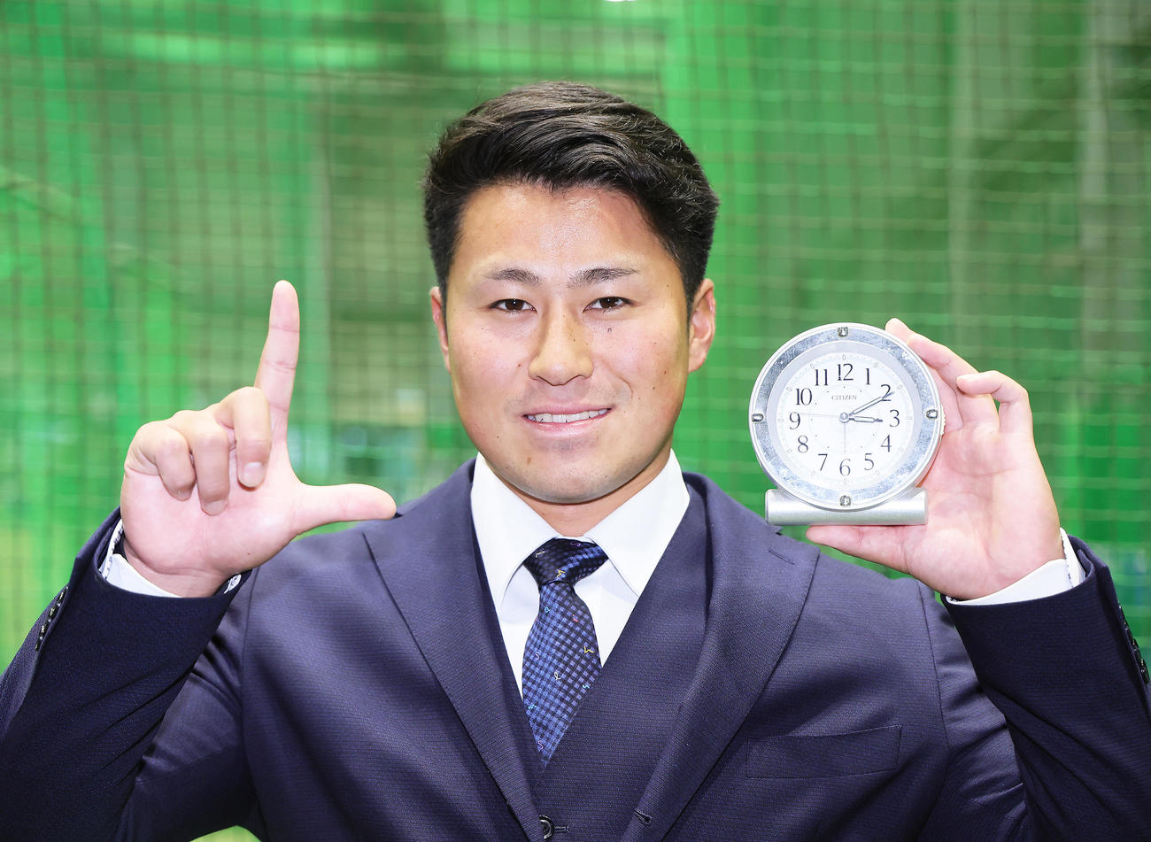 1月7日に入寮し、お気に入りの目覚まし時計を手に笑顔を見せる西武ドラフト2位大商大・渡部聖（撮影・足立雅史）