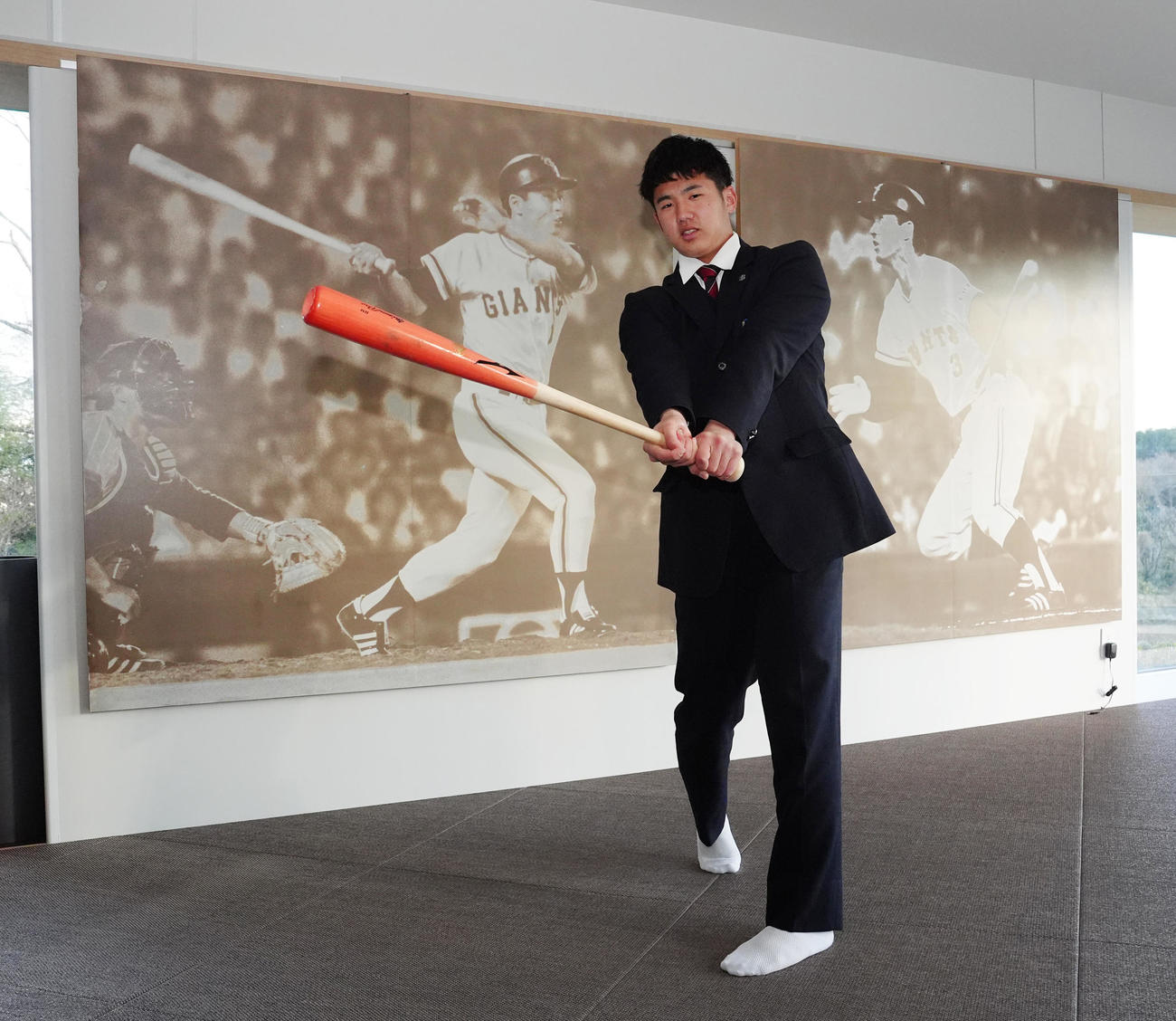 入寮し、王、長嶋両氏の写真パネルが飾られるスイングルームでバットを手にする巨人ドラフト1位の石塚（撮影・江口和貴）
