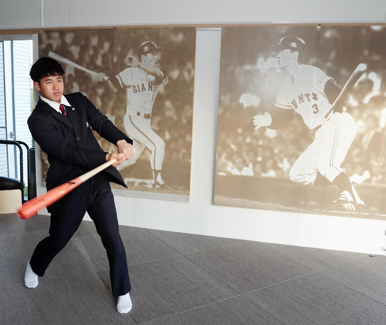 入寮し、王、長嶋両氏の写真パネルが飾られるスイングルームでバットを振る巨人ドラフト1位の石塚（撮影・江口和貴）